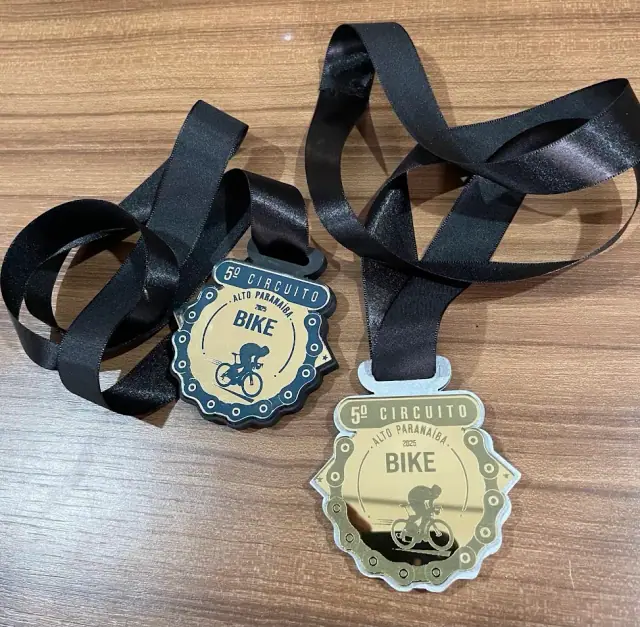 Duas medalhas de circuito de bike com fitas pretas e centro azul e dourado