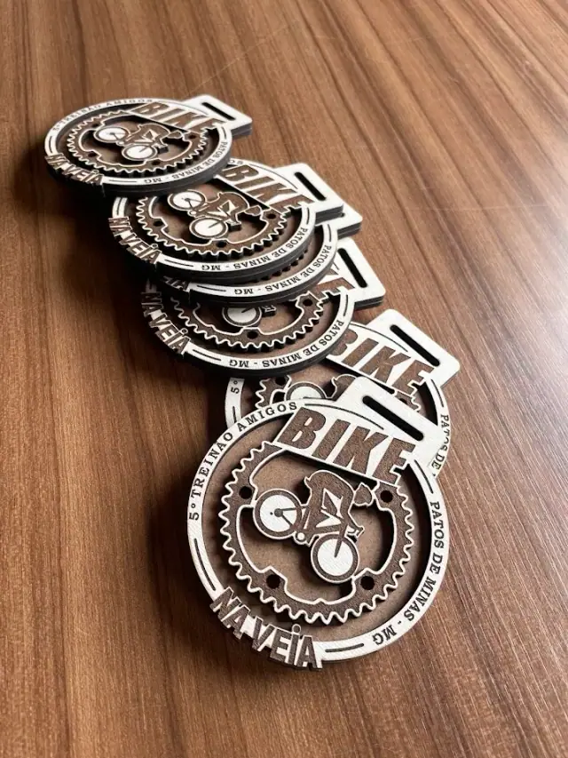 Medalhas recortadas com bicicleta e contorno de engrenagem sobre mesa