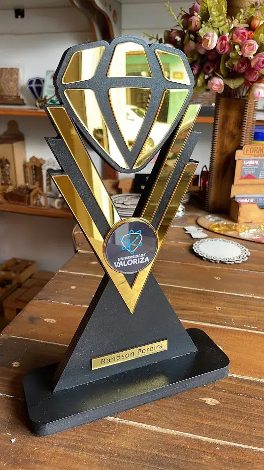 Troféu preto e dourado com desenho recortado de diamante e base larga